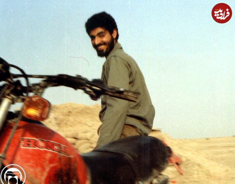 تاریخ و سفر در زمان؛ (عکس) به چهرۀ خندان «سردار سلیمانی» کنار موتورسیکلتش جبهه دهۀ 60